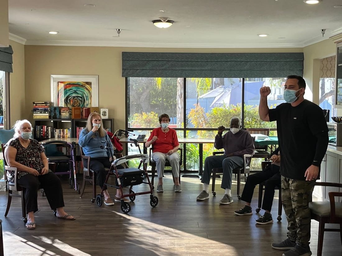 Coach Dean leading a seated boxing class at a senior community